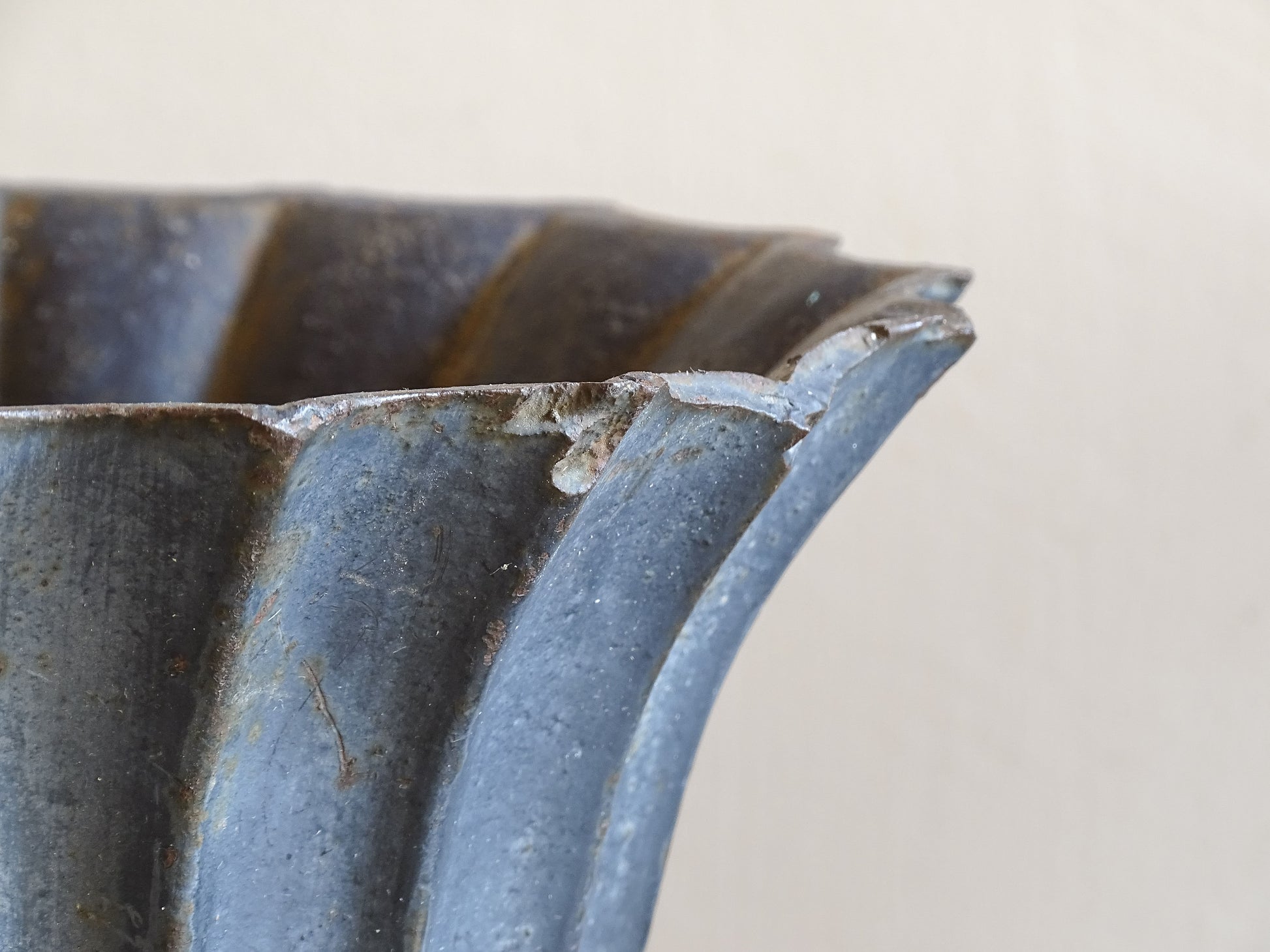 A sculptural pair of French antique cast iron urn planters, with fluted bowls set on stepped bases and raised on paw feet. These antique planters date to to the latter part of the 19th century. They have developed a deep, dark patina.