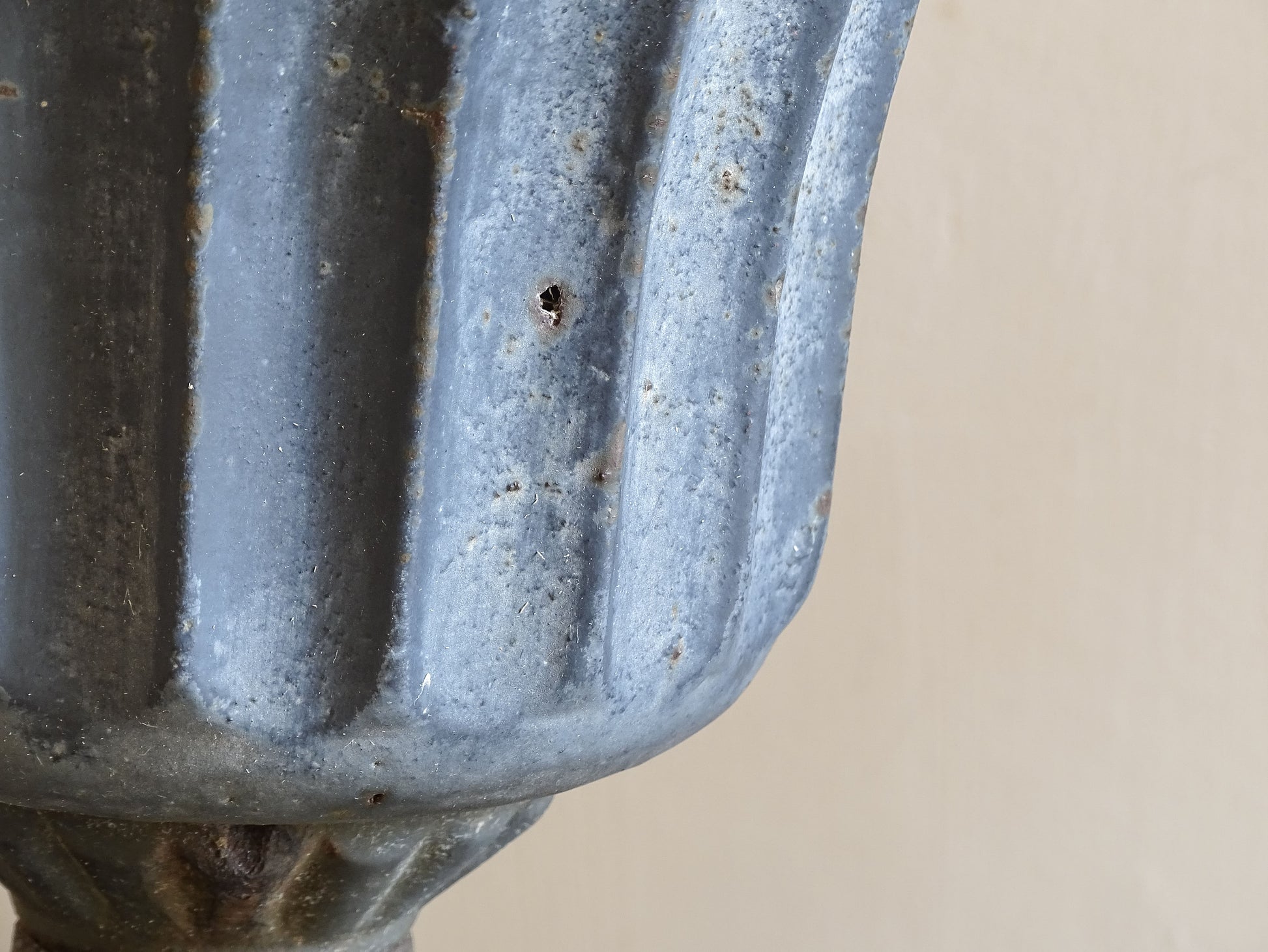 A sculptural pair of French antique cast iron urn planters, with fluted bowls set on stepped bases and raised on paw feet. These antique planters date to to the latter part of the 19th century. They have developed a deep, dark patina.