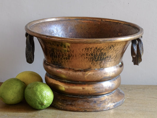 French antique hammered copper planter with iron handles. The copper has developed a rich, lived-in patina, with darker areas around the handles and base.