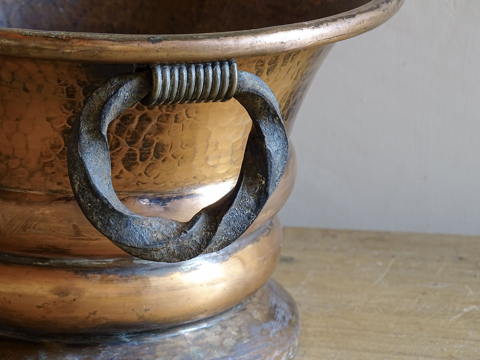 French antique hammered copper planter with iron handles. The copper has developed a rich, lived-in patina, with darker areas around the handles and base.
