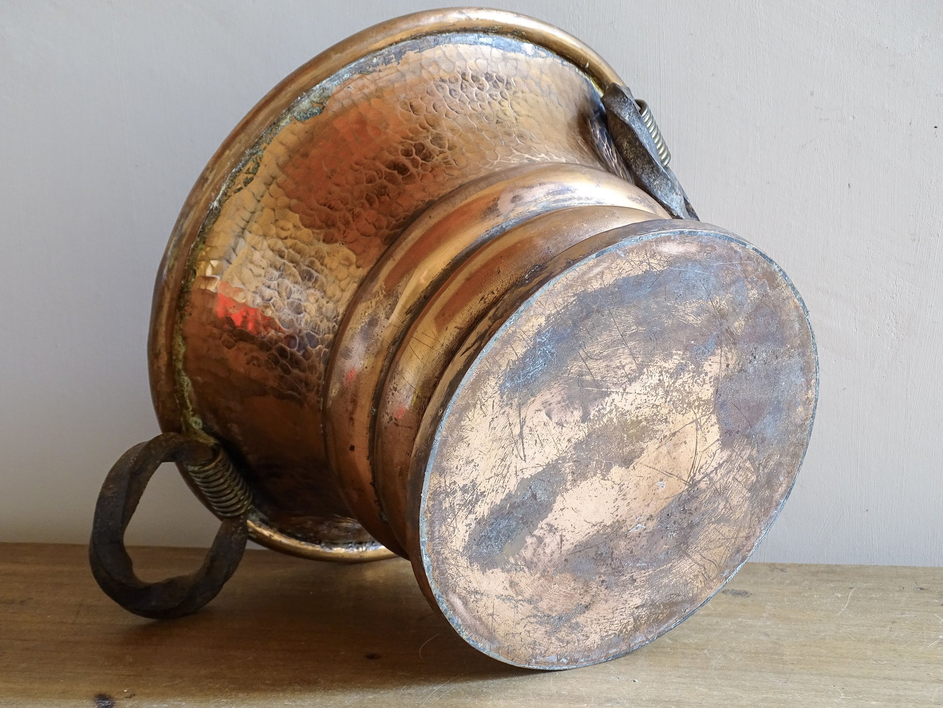 French antique hammered copper planter with iron handles. The copper has developed a rich, lived-in patina, with darker areas around the handles and base.