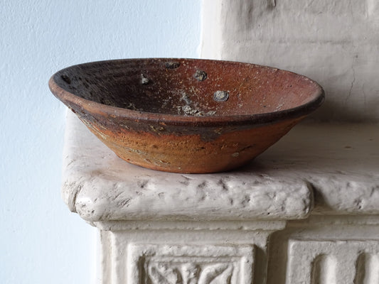Rustic French antique earthenware pottery bowl displayed on a country house fireplace