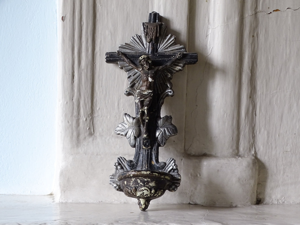 French antique holy water font or benitier in plaster, pictured on a country house fireplace.