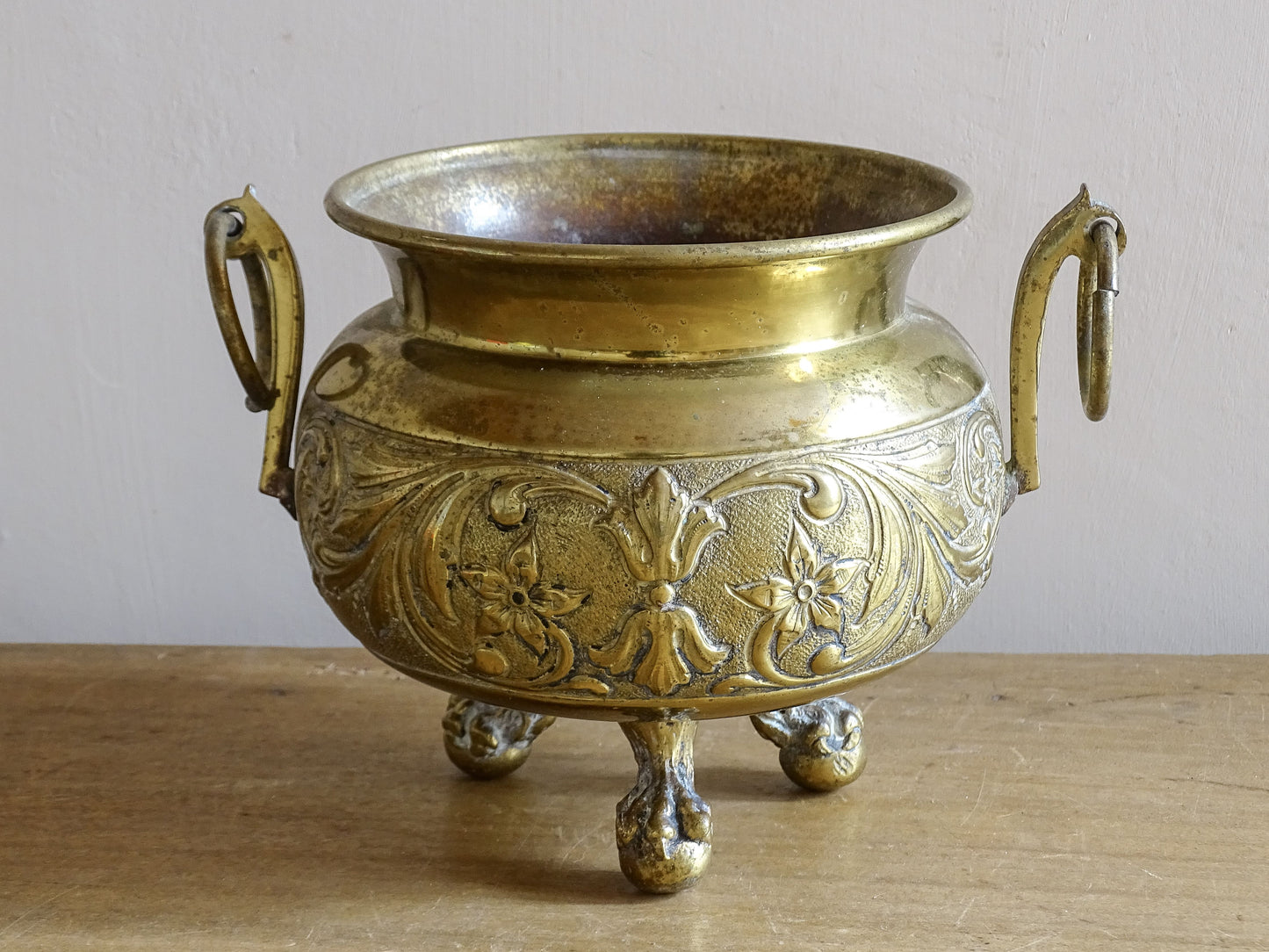 Highly ornate French antique brass jardinière with ball and claw feet. Dating to the late nineteenth century. It is such a decorative piece with richly detailed floral and scrolling relief.