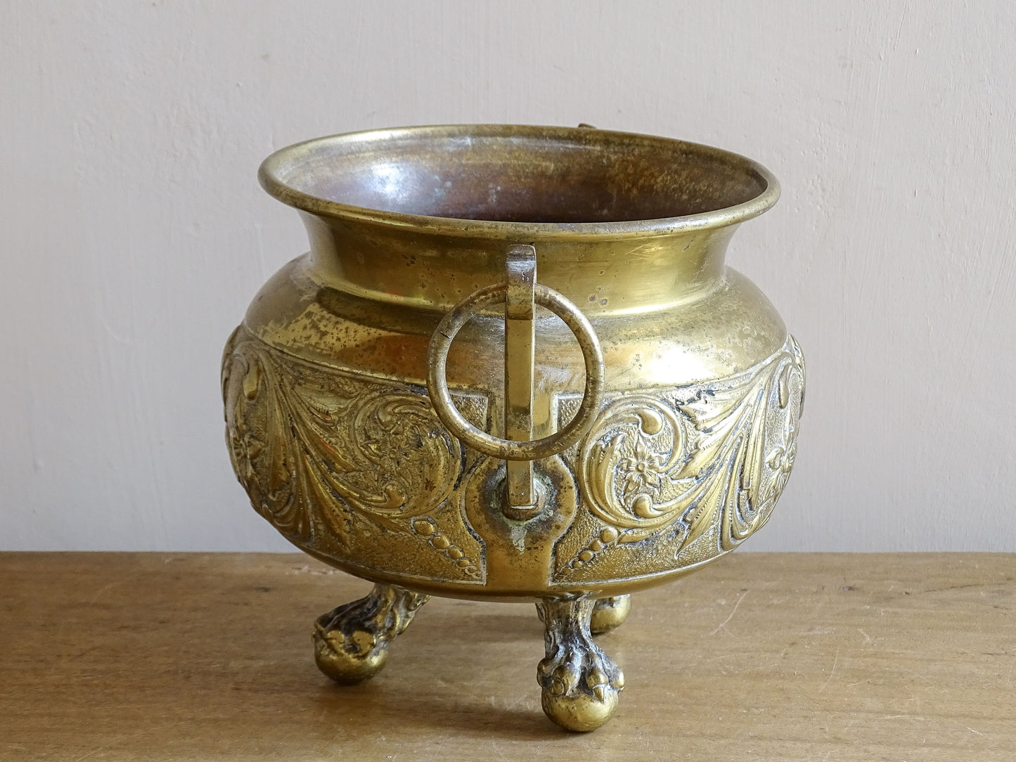 Highly ornate French antique brass jardinière with ball and claw feet. Dating to the late nineteenth century. It is such a decorative piece with richly detailed floral and scrolling relief.