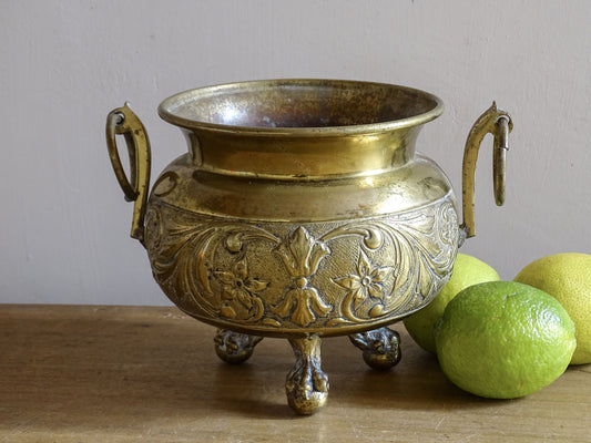 Highly ornate French antique brass jardinière with ball and claw feet. Dating to the late nineteenth century. It is such a decorative piece with richly detailed floral and scrolling relief.