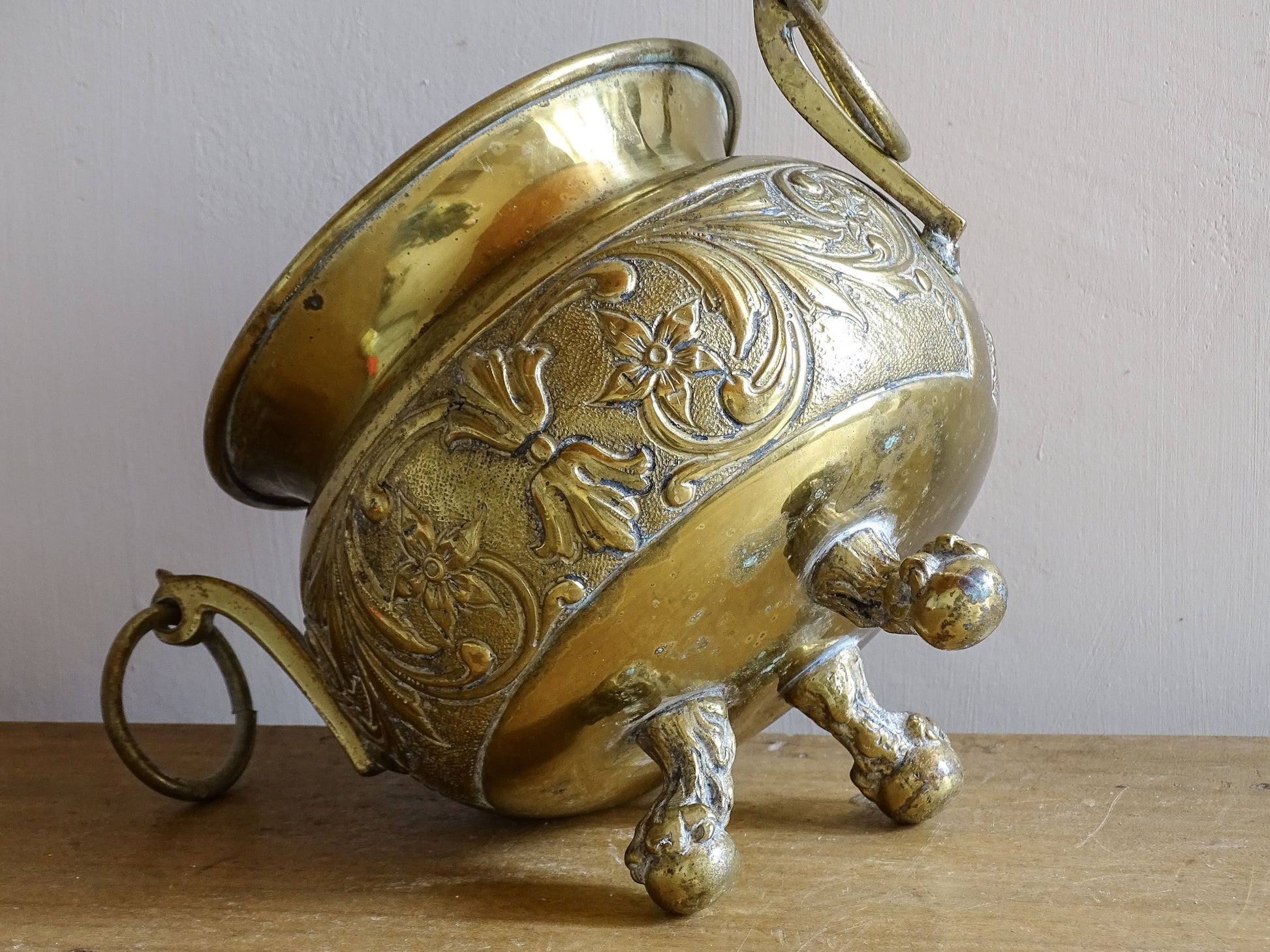 Highly ornate French antique brass jardinière with ball and claw feet. Dating to the late nineteenth century. It is such a decorative piece with richly detailed floral and scrolling relief.