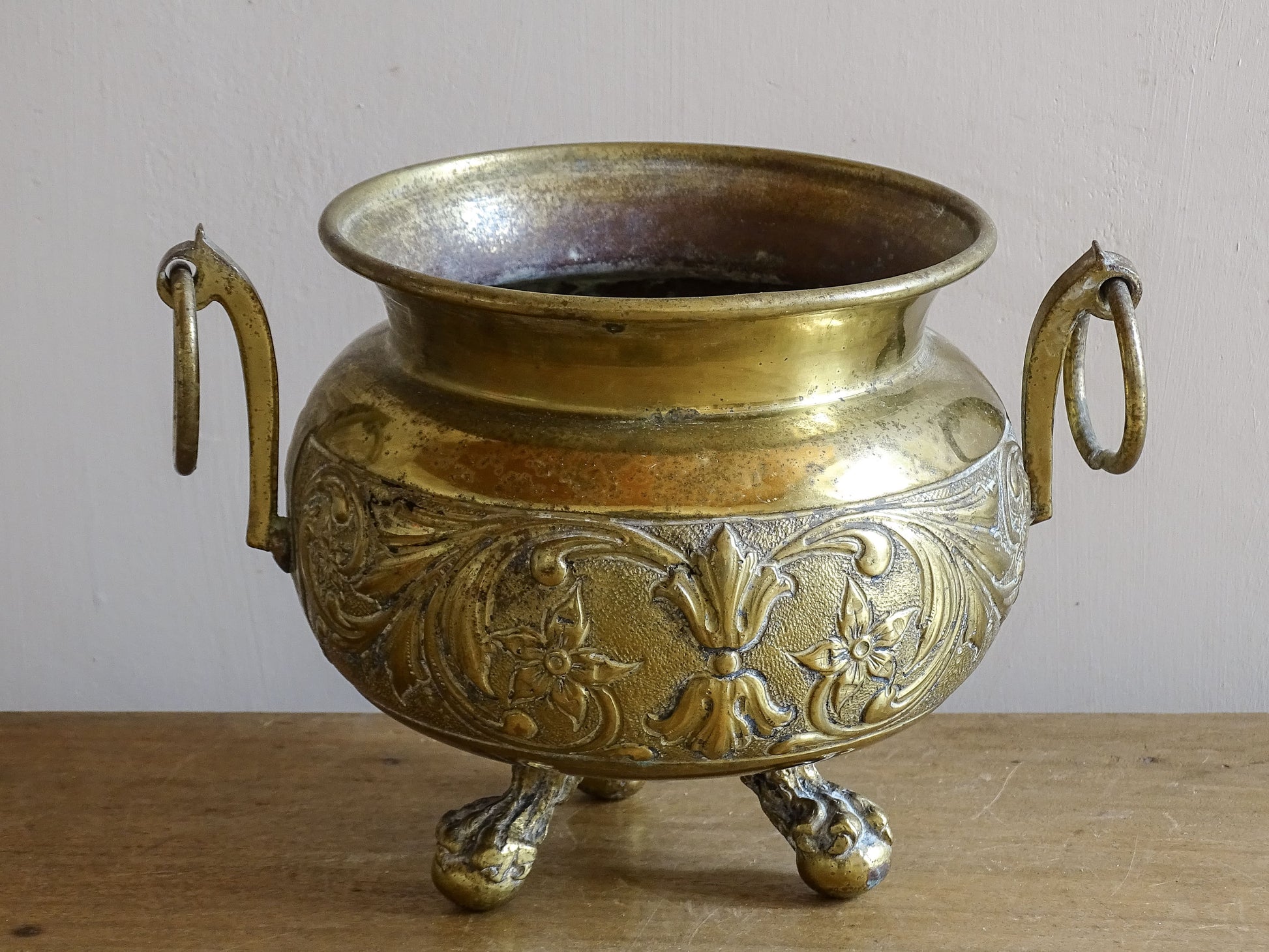 Highly ornate French antique brass jardinière with ball and claw feet. Dating to the late nineteenth century. It is such a decorative piece with richly detailed floral and scrolling relief.