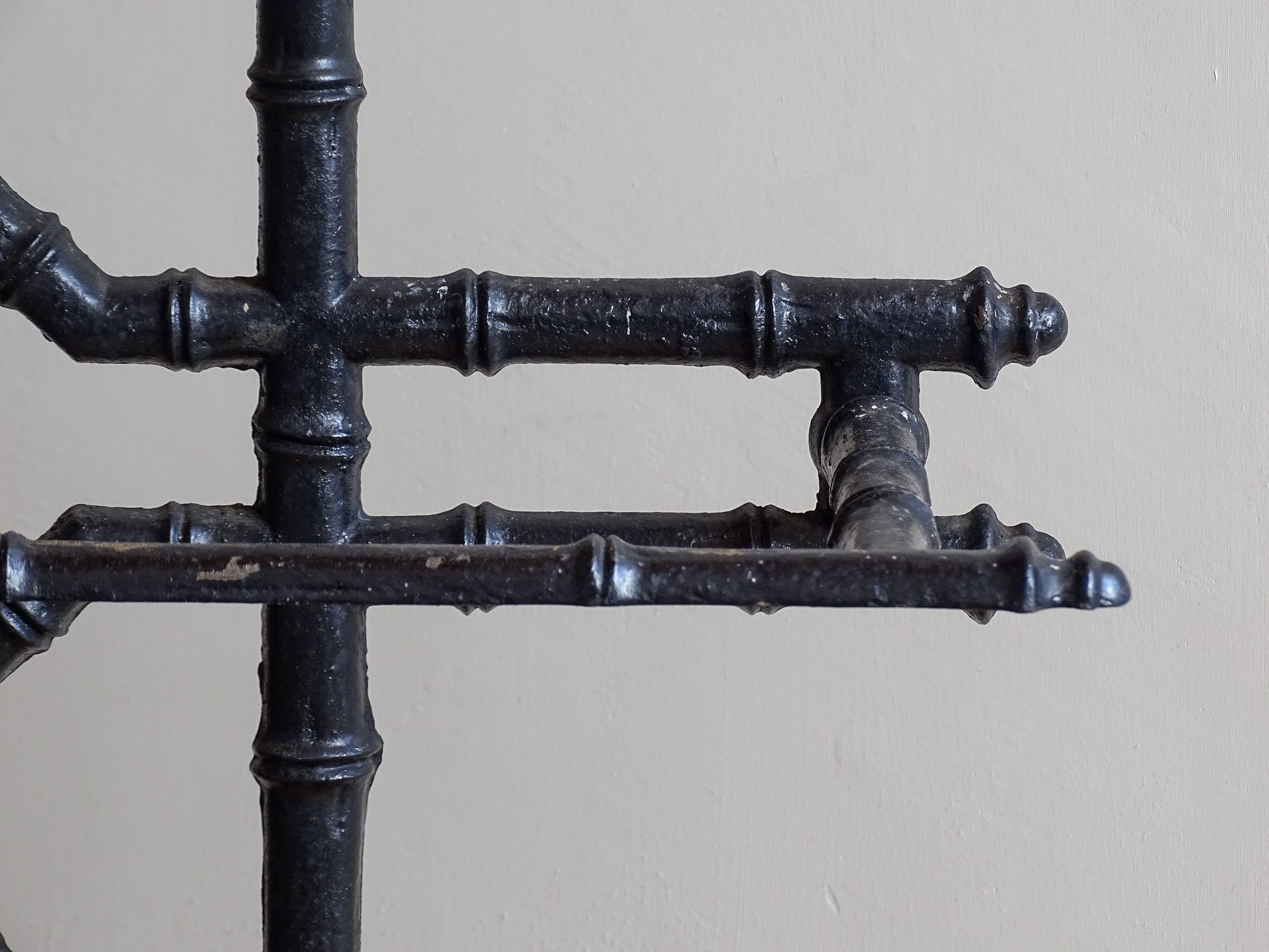 A striking French antique umbrella stand in cast iron, featuring an intricate bamboo-form design with geometric lattice detailing and original drip trays. Dating to the late 19th century