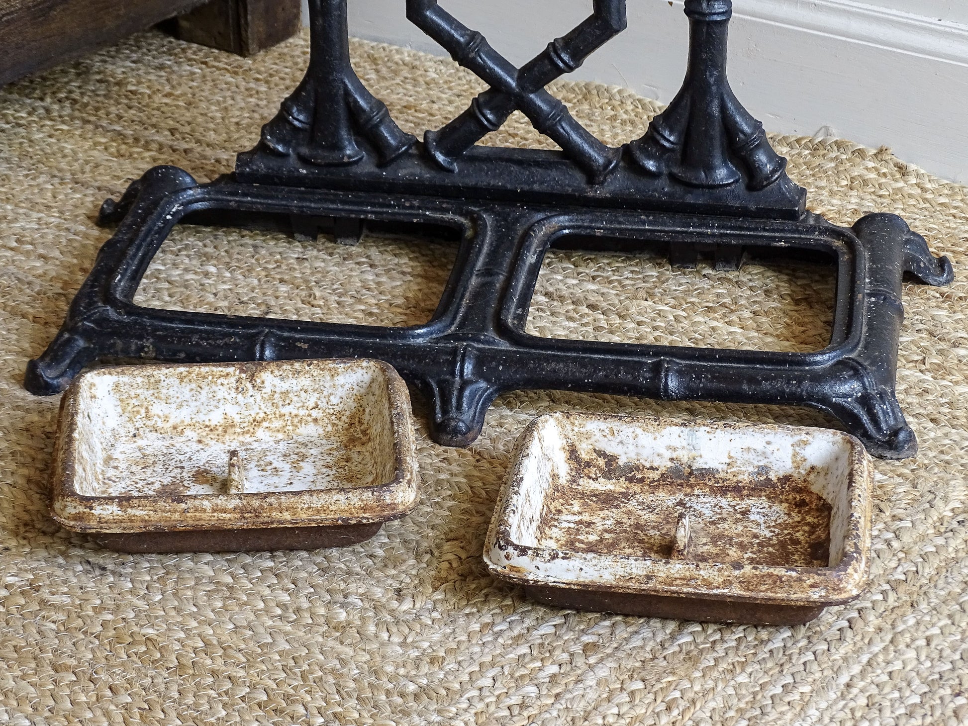 A striking French antique umbrella stand in cast iron, featuring an intricate bamboo-form design with geometric lattice detailing and original drip trays. Dating to the late 19th century