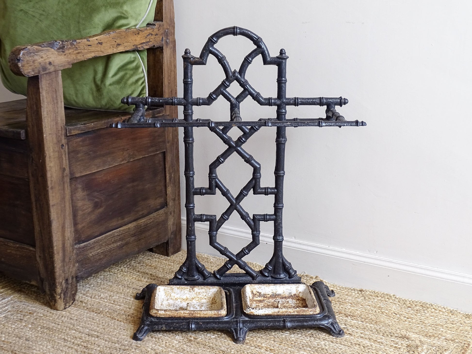 A striking French antique umbrella stand in cast iron, featuring an intricate bamboo-form design with geometric lattice detailing and original drip trays. Dating to the late 19th century