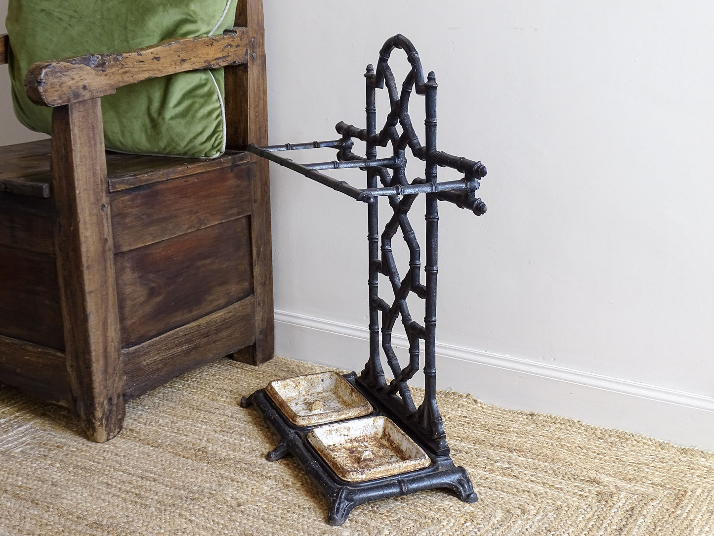 A striking French antique umbrella stand in cast iron, featuring an intricate bamboo-form design with geometric lattice detailing and original drip trays. Dating to the late 19th century