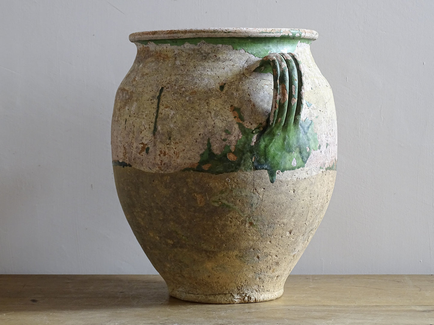 A French antique confit pot from the South West of France, dating to the early to mid 19th century. Hand-thrown in terracotta, the pot has a classic, gently tapered form with two loop handles and a slightly flared rim. 