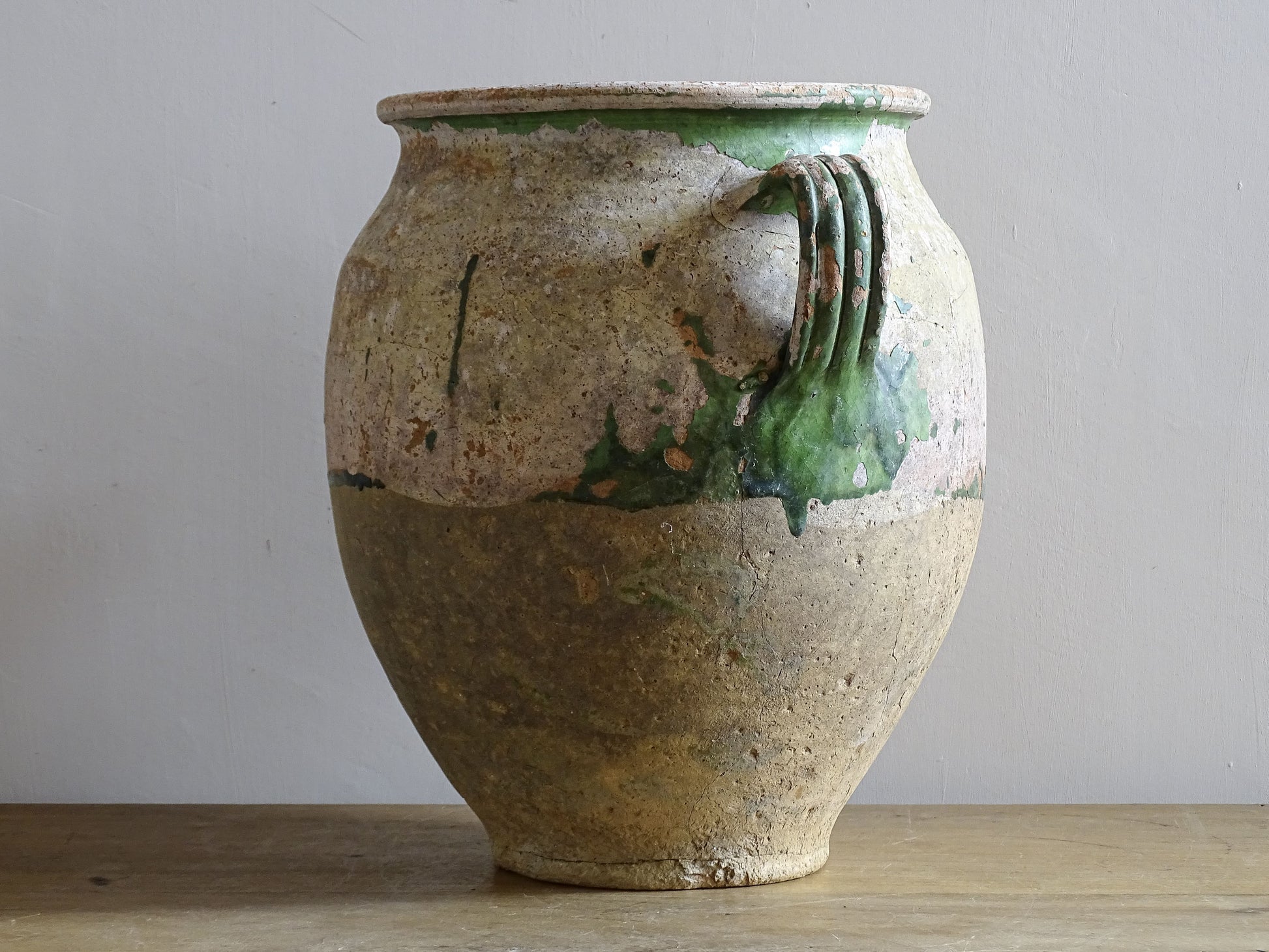 A French antique confit pot from the South West of France, dating to the early to mid 19th century. Hand-thrown in terracotta, the pot has a classic, gently tapered form with two loop handles and a slightly flared rim. 