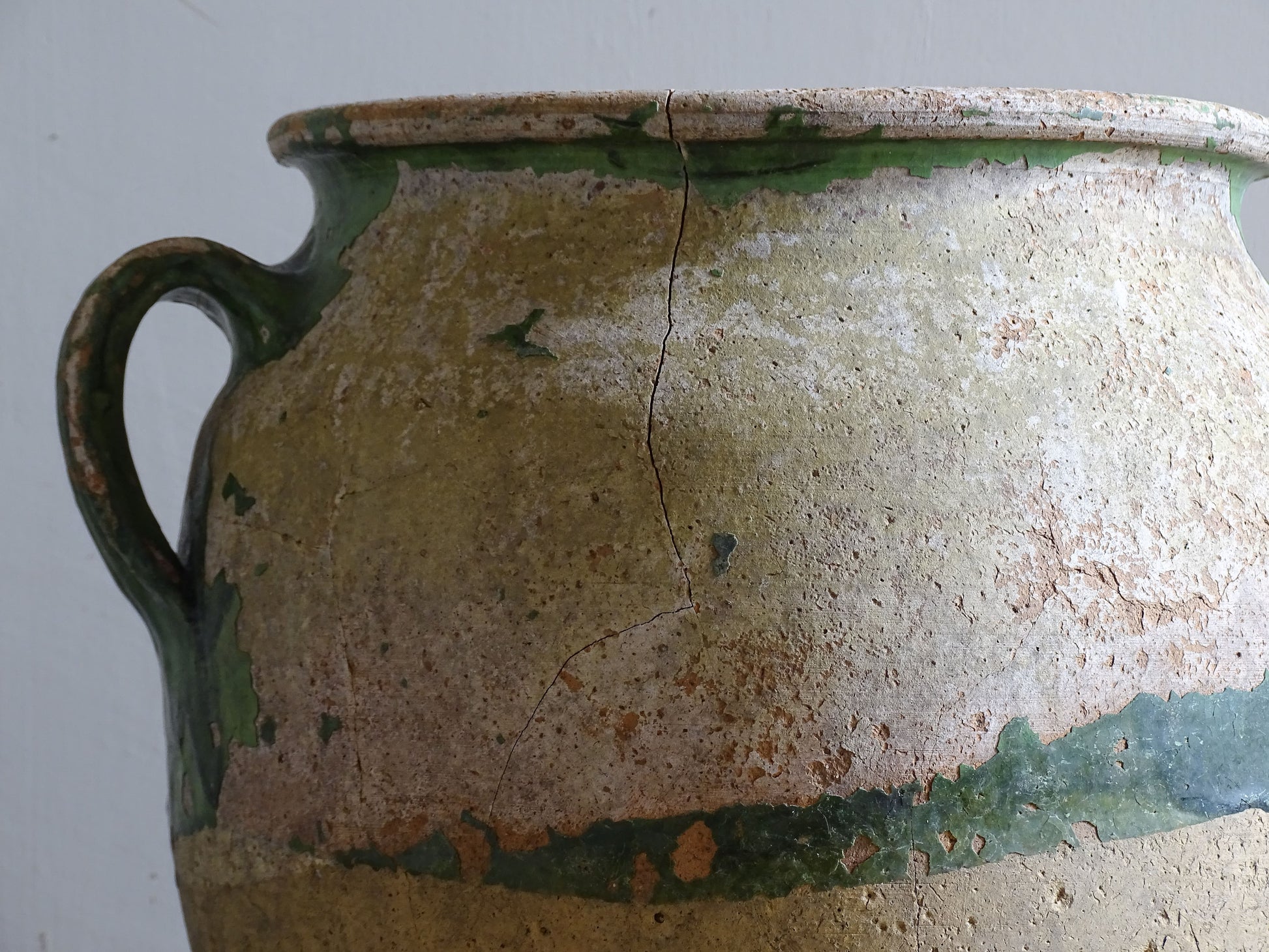 A French antique confit pot from the South West of France, dating to the early to mid 19th century. Hand-thrown in terracotta, the pot has a classic, gently tapered form with two loop handles and a slightly flared rim. 