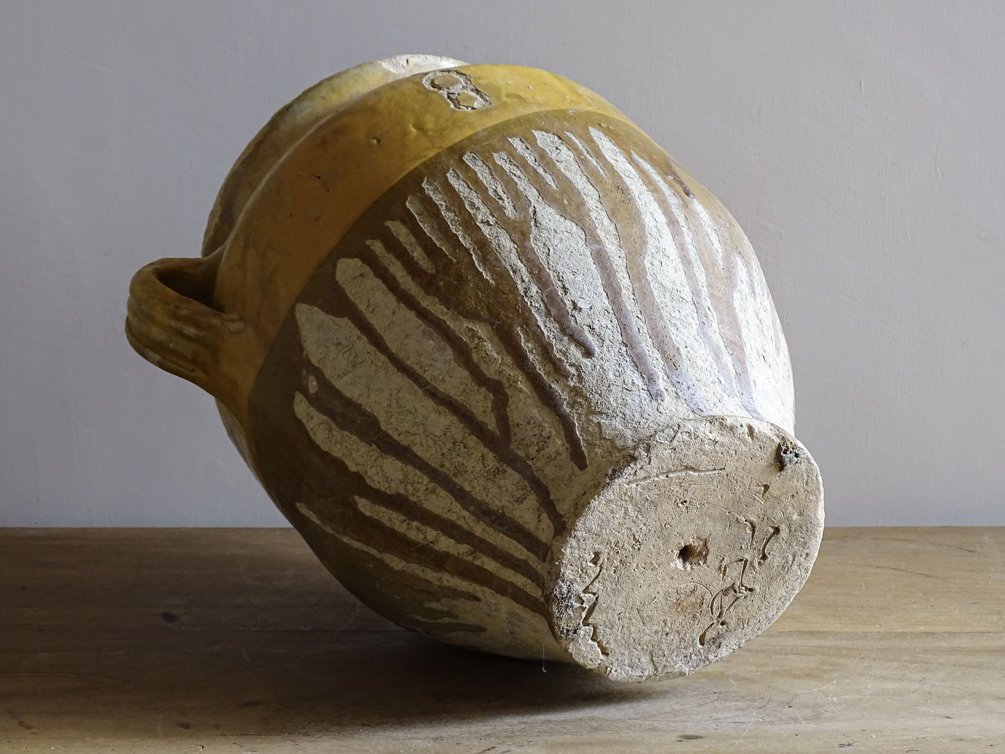 A large French antique confit pot in terracotta with two handles. Dating to the late 19th century and finished with a warm yellow glaze across the upper half.