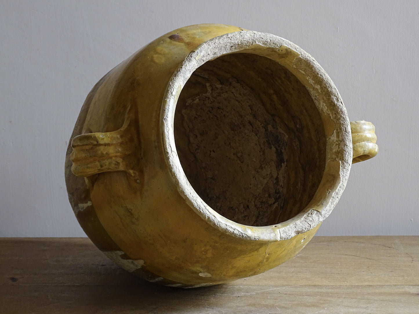 A large French antique confit pot in terracotta with two handles. Dating to the late 19th century and finished with a warm yellow glaze across the upper half.
