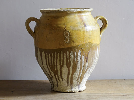 A large French antique confit pot in terracotta with two handles. Dating to the late 19th century and finished with a warm yellow glaze across the upper half.