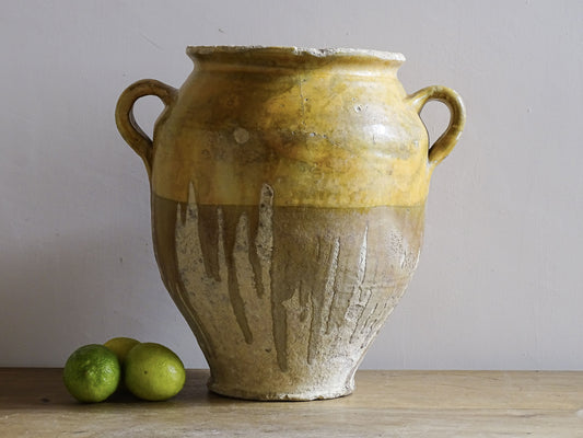 A large French antique confit pot in terracotta with two handles. Dating to the late 19th century and finished with a warm yellow glaze across the upper half.