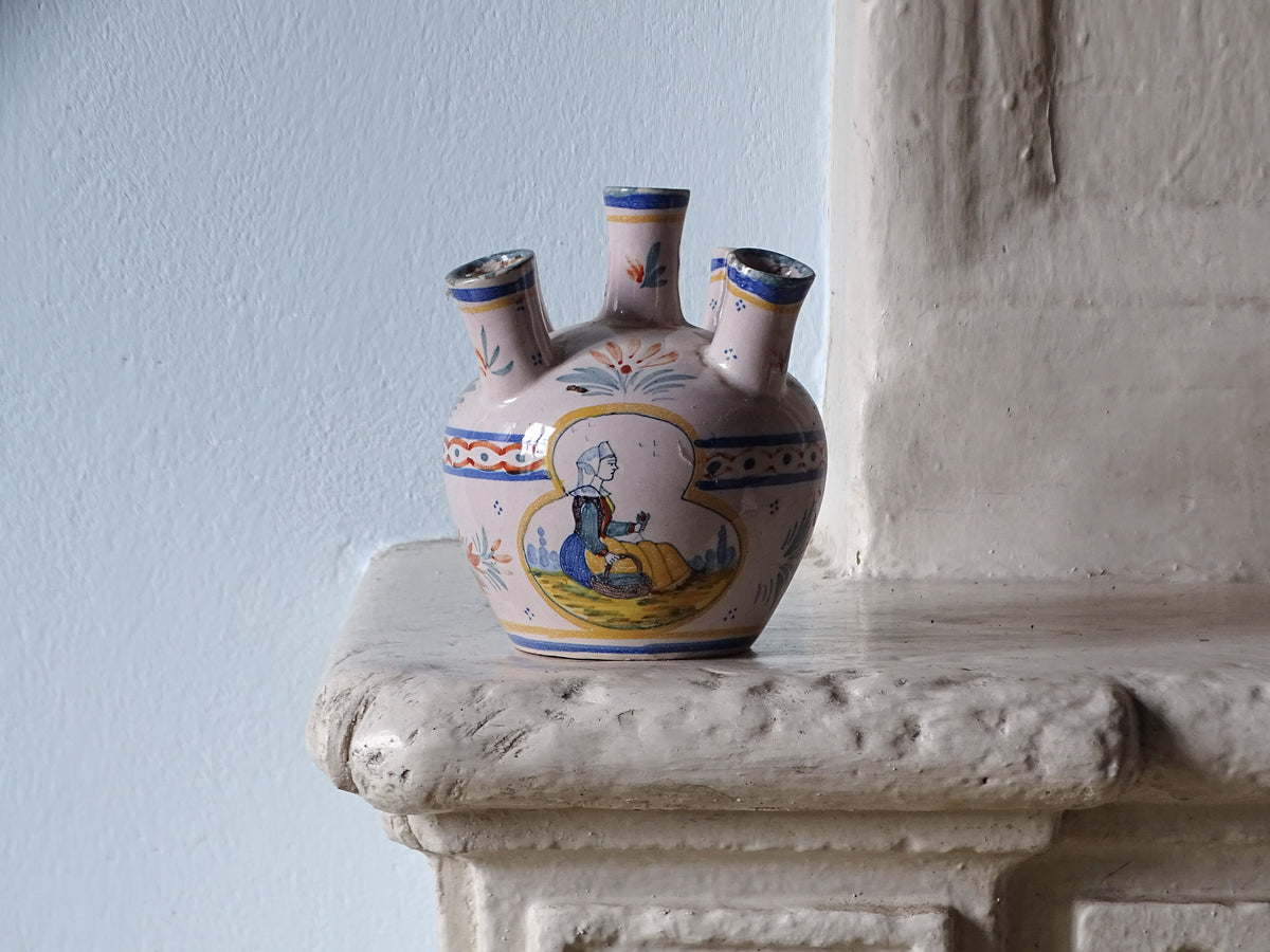 French antique ceramic tulip vase by Quimper, pictured on a country house fireplace