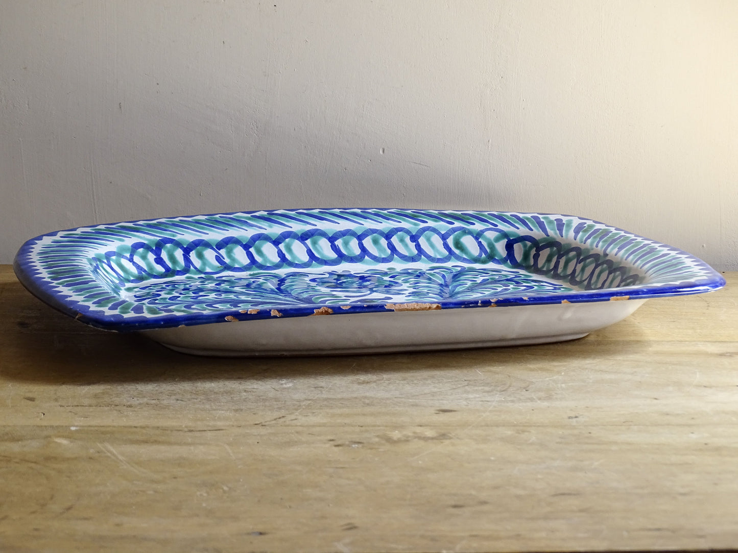 A striking Spanish vintage Fajalauza platter, hand-painted in cobalt blue and soft green on a white ground. The design features flowing foliate motifs and stylised floral details.