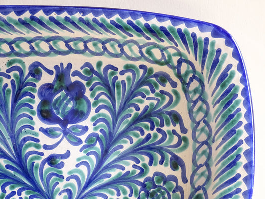 A striking Spanish vintage Fajalauza platter, hand-painted in cobalt blue and soft green on a white ground. The design features flowing foliate motifs and stylised floral details.