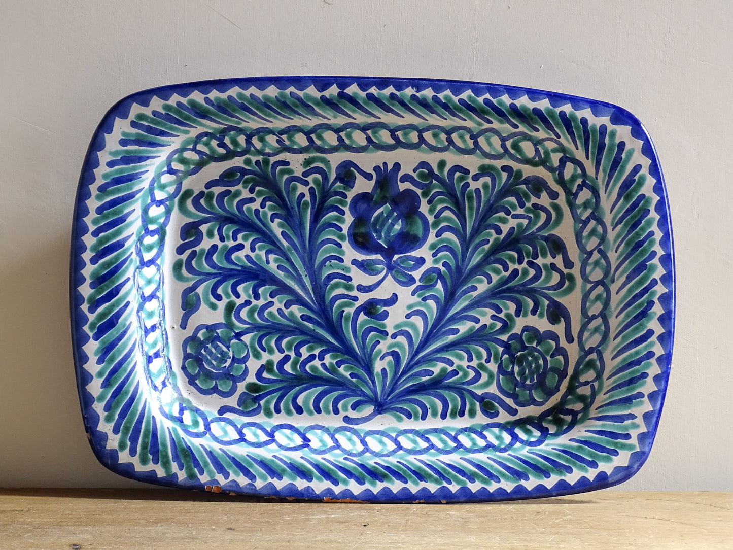 A striking Spanish vintage Fajalauza platter, hand-painted in cobalt blue and soft green on a white ground. The design features flowing foliate motifs and stylised floral details.