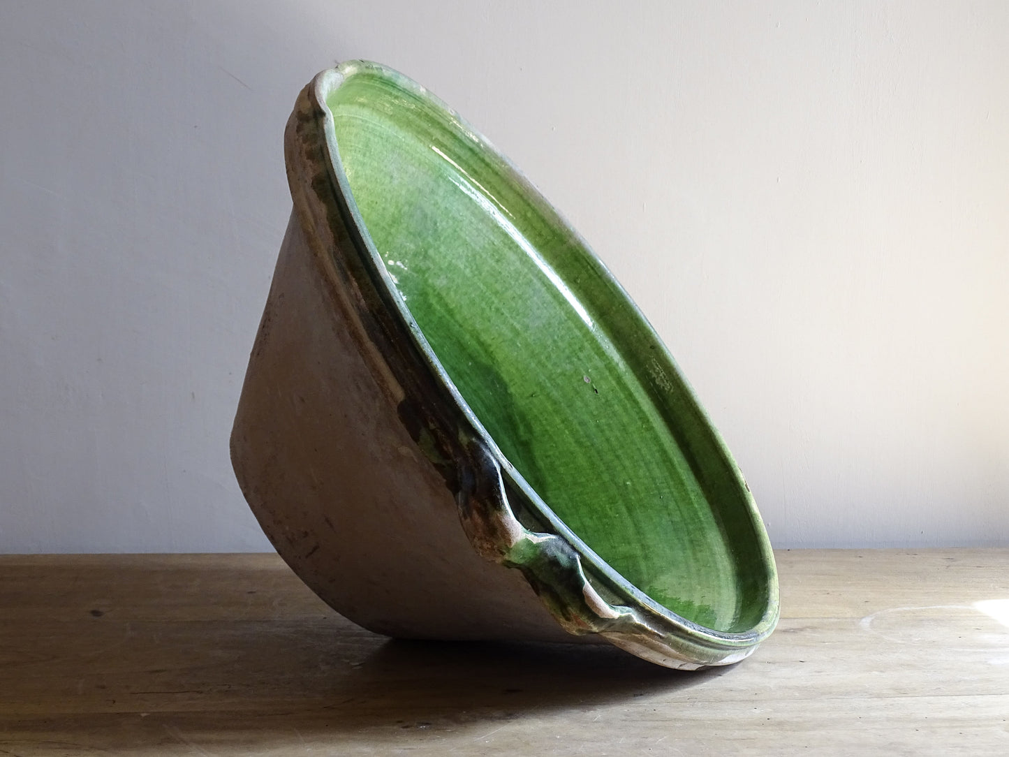 A large and beautifully proportioned antique French tian bowl, finished with a rich green glaze to the interior. Traditionally used in the south of France for preparing and cooking food, this tian bowl has a wide, gently flared form with a pouring lip and applied side handles.