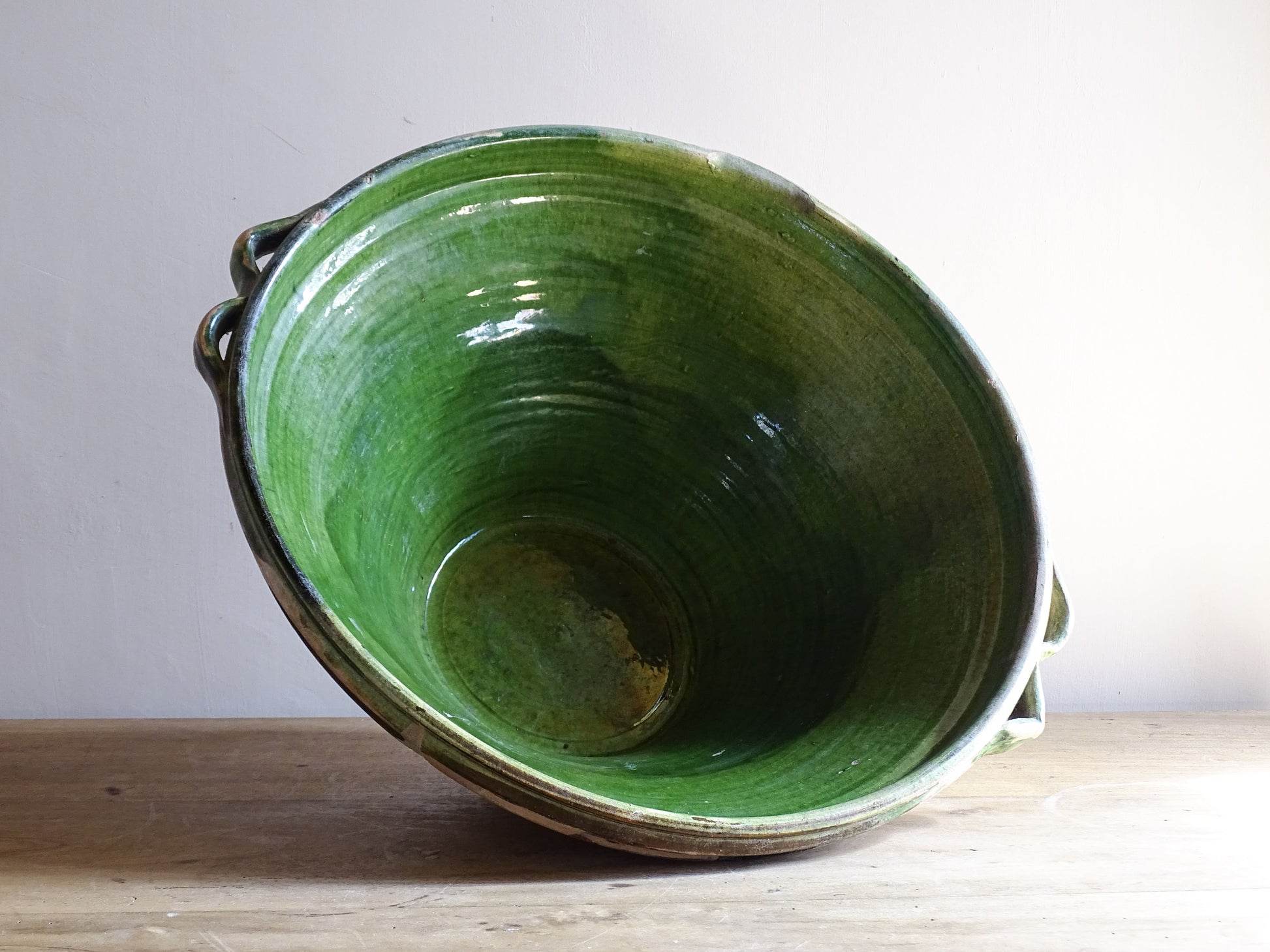 A large and beautifully proportioned antique French tian bowl, finished with a rich green glaze to the interior. Traditionally used in the south of France for preparing and cooking food, this tian bowl has a wide, gently flared form with a pouring lip and applied side handles.