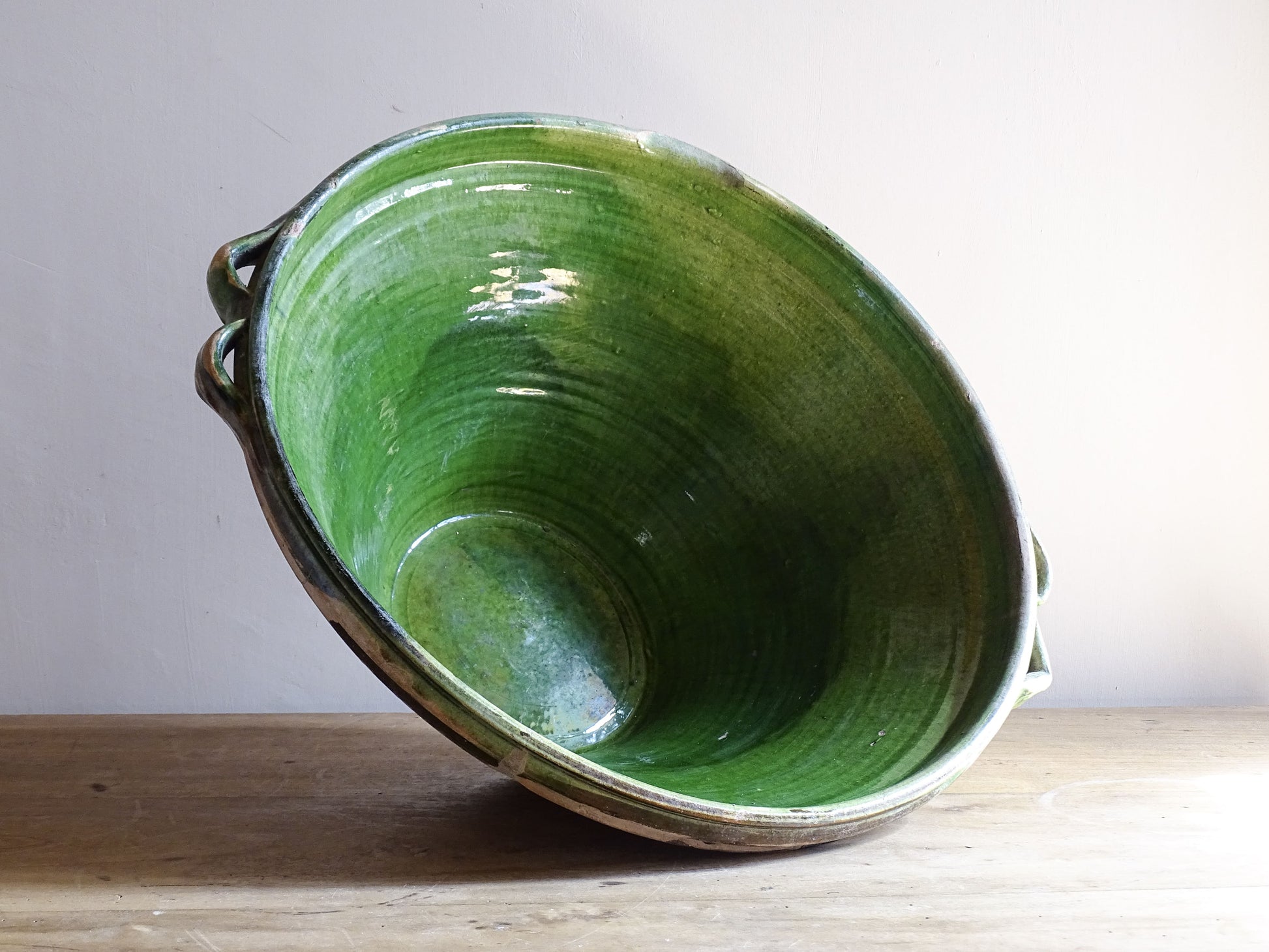 A large and beautifully proportioned antique French tian bowl, finished with a rich green glaze to the interior. Traditionally used in the south of France for preparing and cooking food, this tian bowl has a wide, gently flared form with a pouring lip and applied side handles.