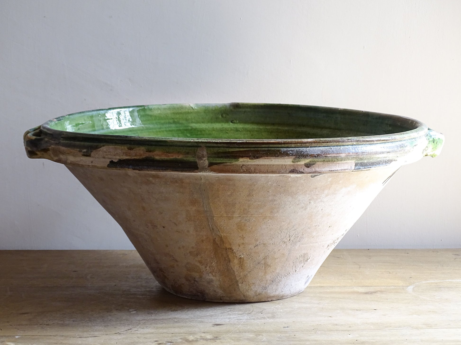 A large and beautifully proportioned antique French tian bowl, finished with a rich green glaze to the interior. Traditionally used in the south of France for preparing and cooking food, this tian bowl has a wide, gently flared form with a pouring lip and applied side handles.