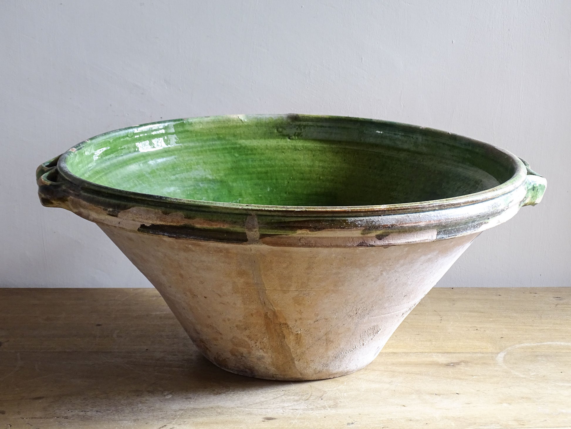 A large and beautifully proportioned antique French tian bowl, finished with a rich green glaze to the interior. Traditionally used in the south of France for preparing and cooking food, this tian bowl has a wide, gently flared form with a pouring lip and applied side handles.