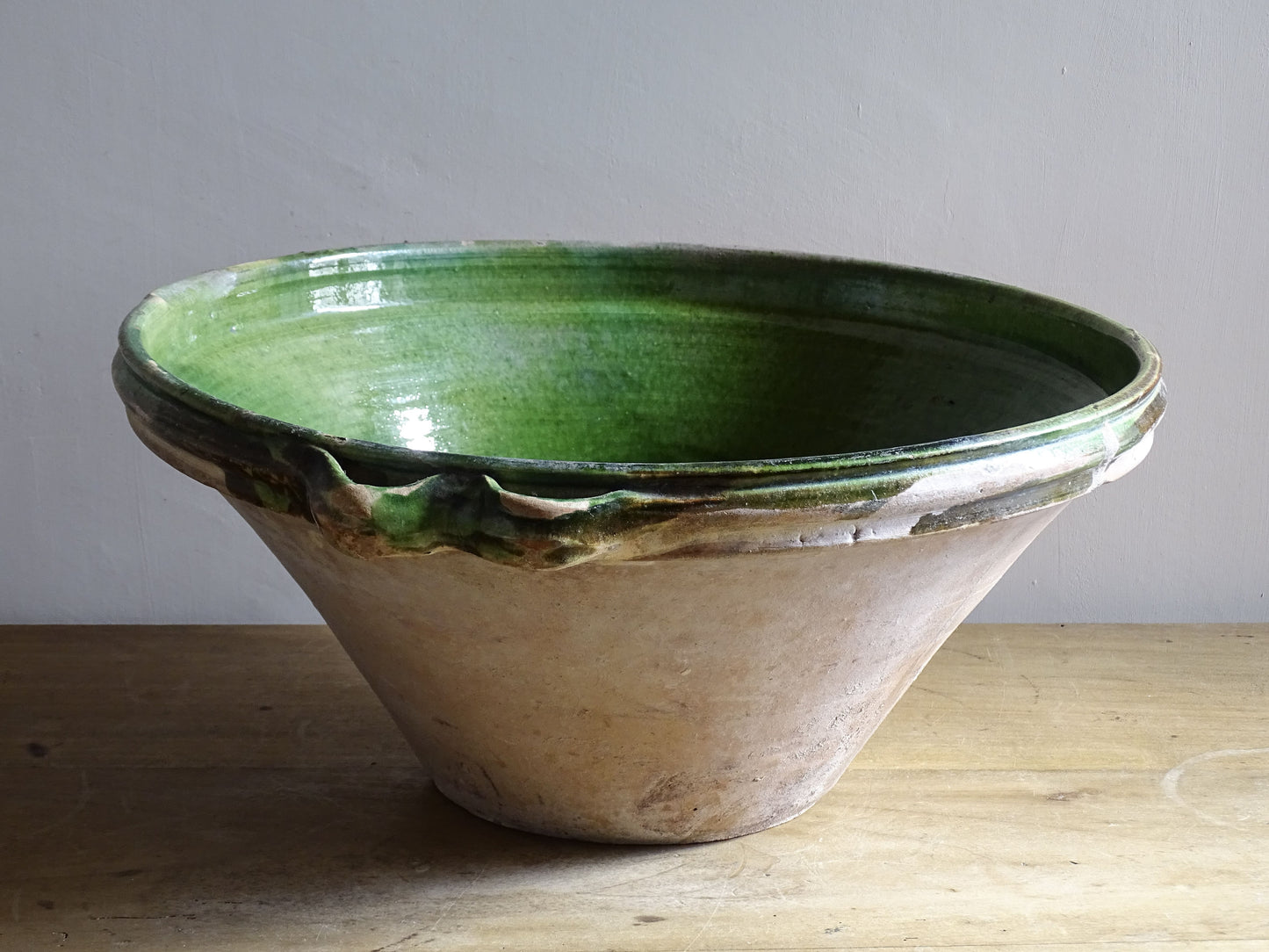 A large and beautifully proportioned antique French tian bowl, finished with a rich green glaze to the interior. Traditionally used in the south of France for preparing and cooking food, this tian bowl has a wide, gently flared form with a pouring lip and applied side handles.