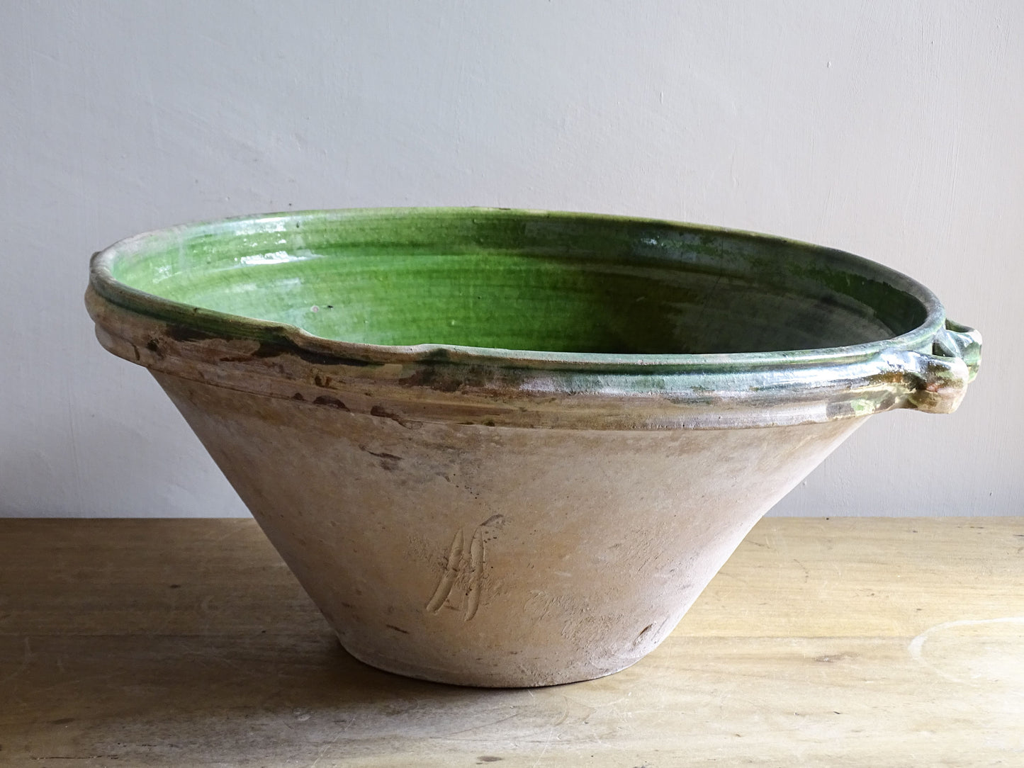 A large and beautifully proportioned antique French tian bowl, finished with a rich green glaze to the interior. Traditionally used in the south of France for preparing and cooking food, this tian bowl has a wide, gently flared form with a pouring lip and applied side handles.