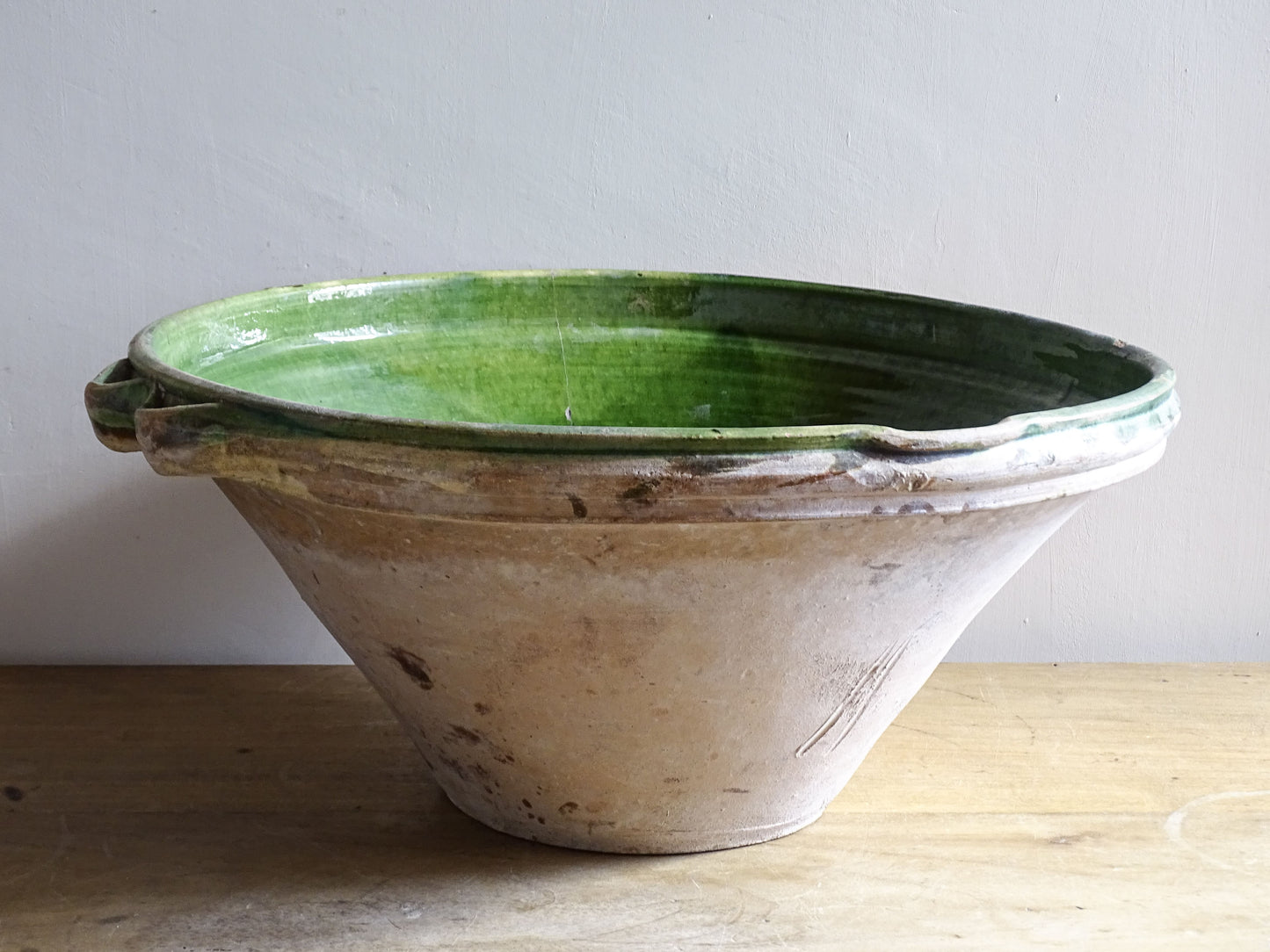 A large and beautifully proportioned antique French tian bowl, finished with a rich green glaze to the interior. Traditionally used in the south of France for preparing and cooking food, this tian bowl has a wide, gently flared form with a pouring lip and applied side handles.