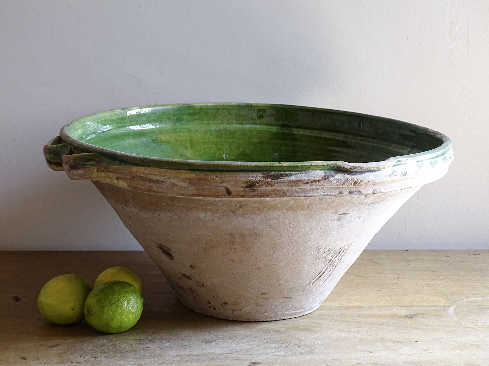 A large and beautifully proportioned antique French tian bowl, finished with a rich green glaze to the interior. Traditionally used in the south of France for preparing and cooking food, this tian bowl has a wide, gently flared form with a pouring lip and applied side handles.