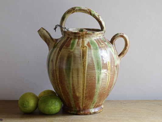 A French antique ceramic water jug or gargoulette from the South of France, dating to the late 19th century.
This French antique gargoulette is formed in terracotta and finished with a flowing green and yellow glaze.