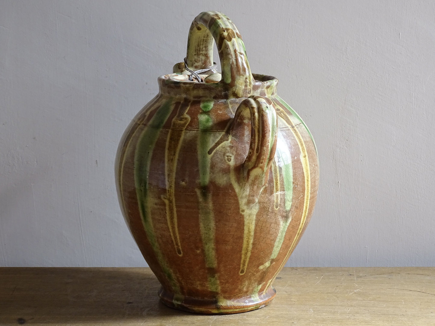 A French antique ceramic water jug or gargoulette from the South of France, dating to the late 19th century. This French antique gargoulette is formed in terracotta and finished with a flowing green and yellow glaze