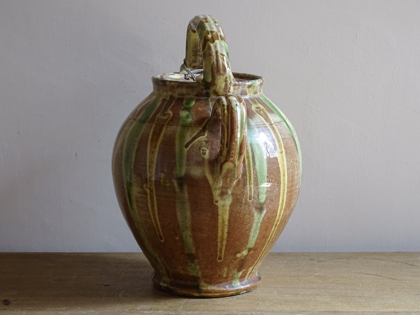 A French antique ceramic water jug or gargoulette from the South of France, dating to the late 19th century. This French antique gargoulette is formed in terracotta and finished with a flowing green and yellow glaze