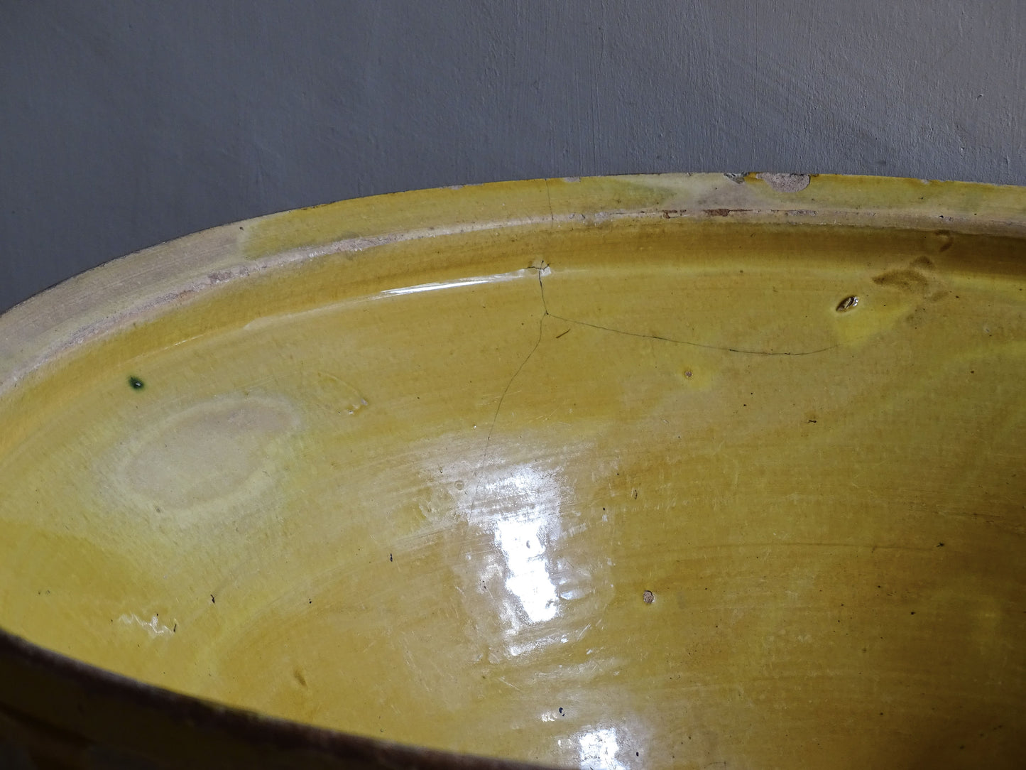 A large French antique tian bowl in pale terracotta, finished with a warm yellow glazed interior. Hand-thrown with a wide, gently flared form and a thick rolled rim. This tian bowl is typical of traditional farmhouse pottery from the South West of France.