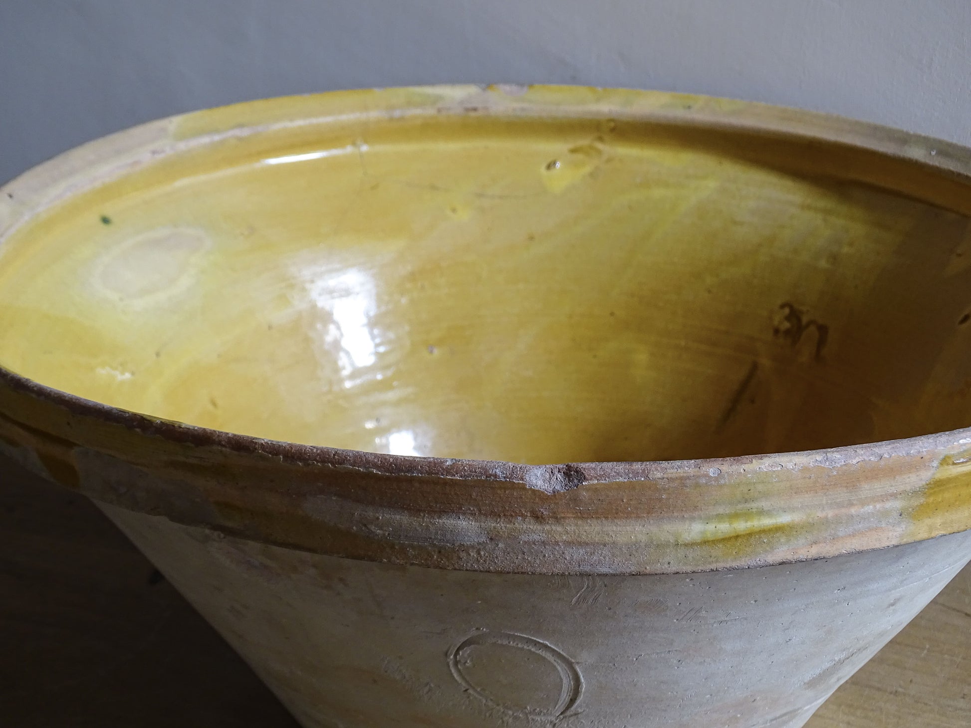 A large French antique tian bowl in pale terracotta, finished with a warm yellow glazed interior. Hand-thrown with a wide, gently flared form and a thick rolled rim. This tian bowl is typical of traditional farmhouse pottery from the South West of France.