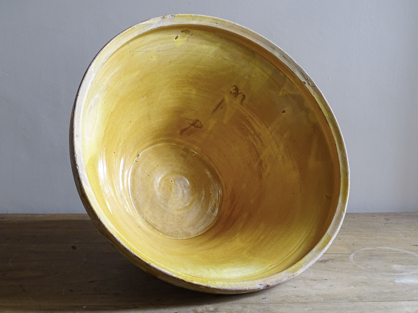 A large French antique tian bowl in pale terracotta, finished with a warm yellow glazed interior. Hand-thrown with a wide, gently flared form and a thick rolled rim. This tian bowl is typical of traditional farmhouse pottery from the South West of France.
