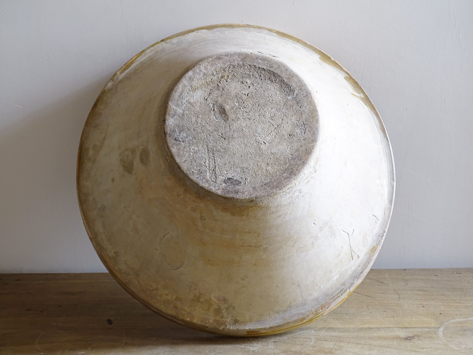 A large French antique tian bowl in pale terracotta, finished with a warm yellow glazed interior. Hand-thrown with a wide, gently flared form and a thick rolled rim. This tian bowl is typical of traditional farmhouse pottery from the South West of France.