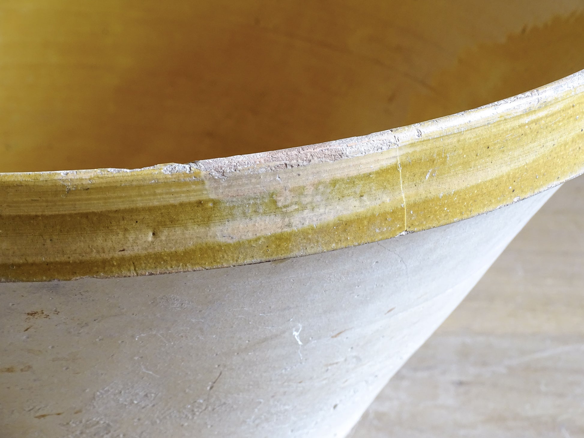 A large French antique tian bowl in pale terracotta, finished with a warm yellow glazed interior. Hand-thrown with a wide, gently flared form and a thick rolled rim. This tian bowl is typical of traditional farmhouse pottery from the South West of France.