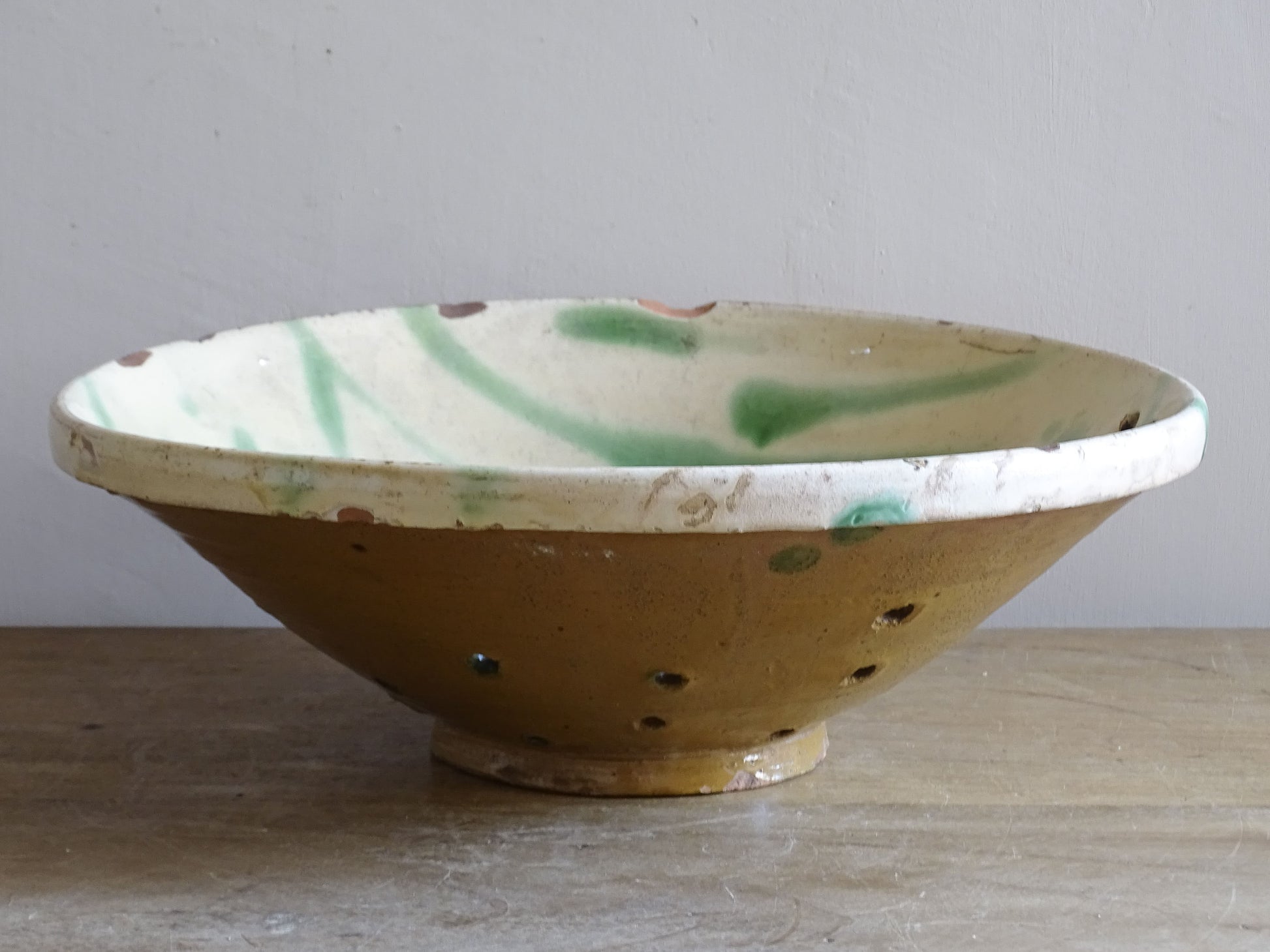 Green glazed French pottery bowl with worn rim and terracotta base