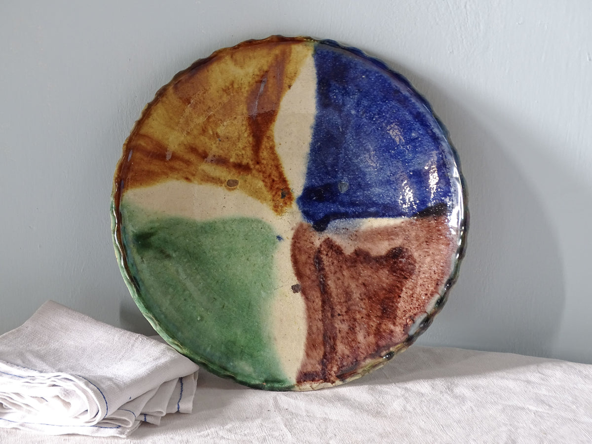 French vintage ceramic plate with a colourful glaze, pictured with antique linen in country house setting