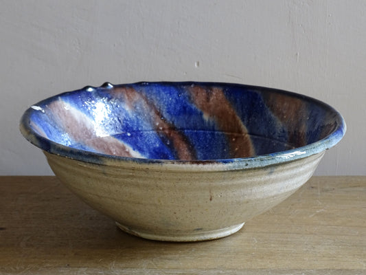 Small French vintage slipware bowl with a jaspe glazed interior in cobalt blue and brown tones. Hand-thrown earthenware with a rustic country pottery character.