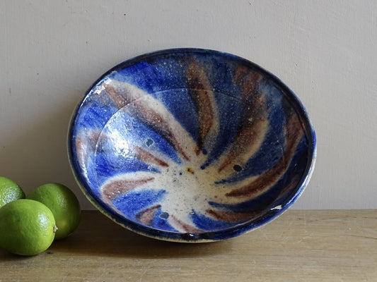 Small French vintage slipware bowl with a jaspe glazed interior in cobalt blue and brown tones. Hand-thrown earthenware with a rustic country pottery character.