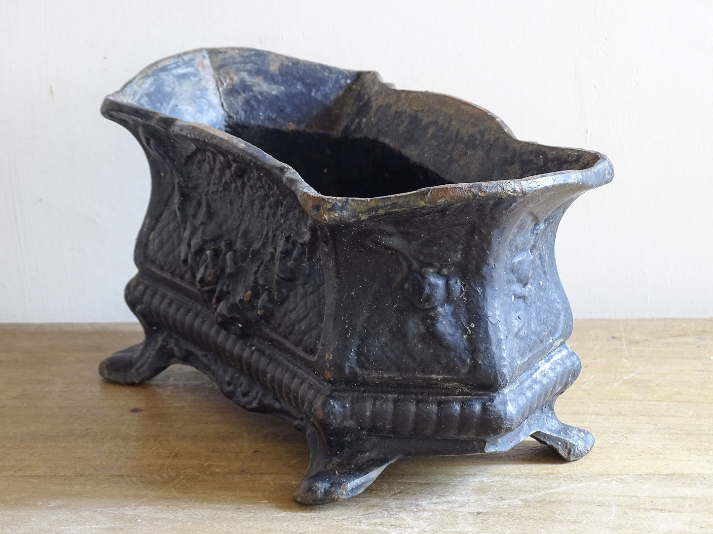 Decorative French cast iron planter with floral motif and dark patina