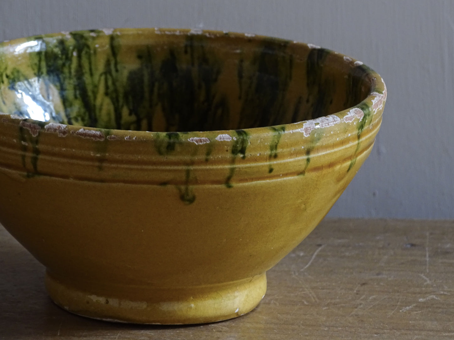  A small French antique terracotta bowl with a striking yellow ochre glaze and a traditional green jaspé decorated interior. Hand-thrown in earthenware.